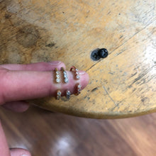 Load image into Gallery viewer, Three Open Graduated Diamond Ring in 14k yellow, white, and rose gold stacked on an index finger displayed on a wooden background.