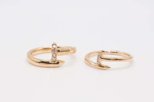 Two different sized Nail Ring in 14K yellow Gold with Diamonds laid flat on a white background.
