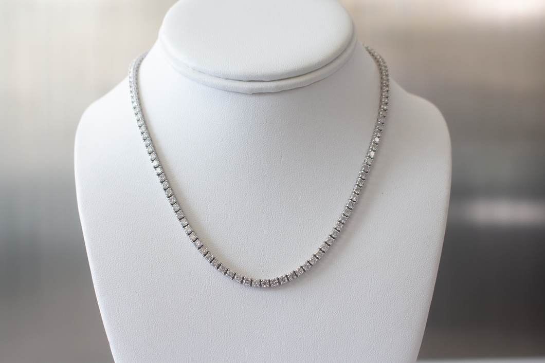 11 Carat Diamond Tennis Necklace in white gold hanging on a white bust.