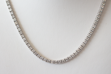 Load image into Gallery viewer, 11 Carat Diamond Tennis Necklace in white gold hanging on a white bust, close up.

