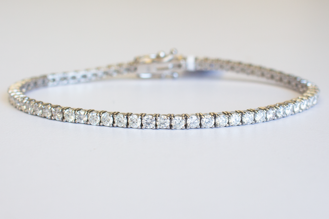 4 Carat Diamond Tennis Bracelet in white gold laid flat in a circle on a white background.