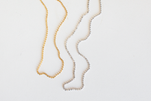 Load image into Gallery viewer, Cassie Genuine 14 karat gold diamond cut beaded choker in yellow gold and white gold laid flat on a white background.
