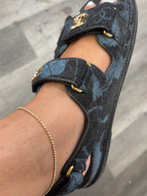 Load image into Gallery viewer, Cassie solid 14k diamond cut anklet in yellow gold on a person&#39;s ankle wearing a sandal on a wood plank background.
