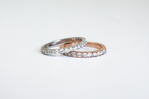 Two Classic 14k Diamond Band in white gold and yellow gold stacked on each other on a white background.
