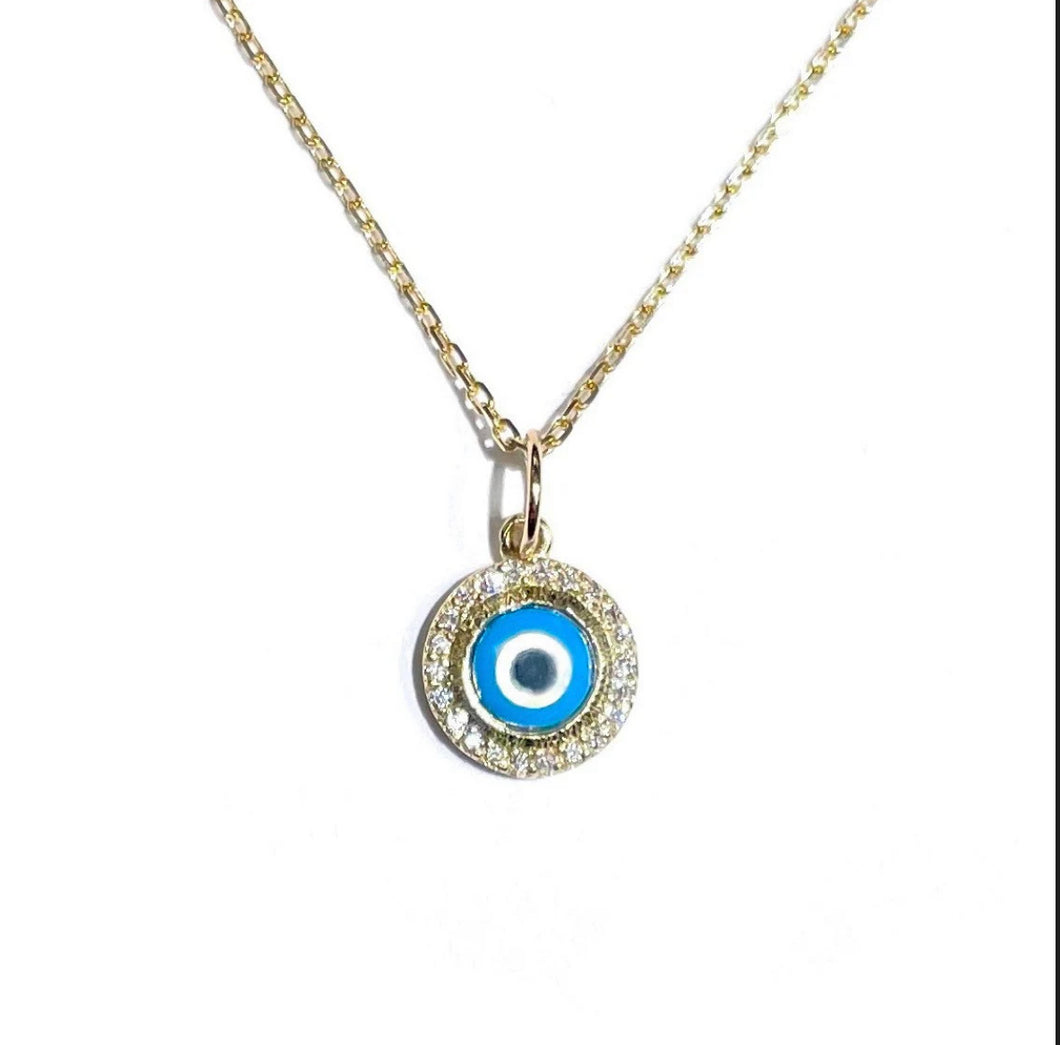 Diamond Bezel Evil Eye Charm in yellow gold hanging on a white background.