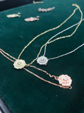 Load image into Gallery viewer, Three Diamond Blossom Necklaces in 14k yellow, white and rose Gold laid flat on a green background.
