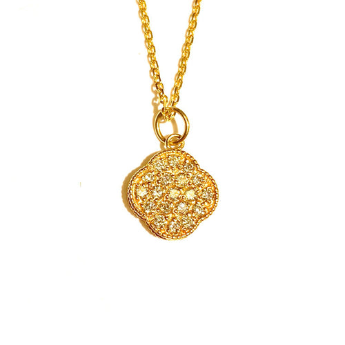 Close up of Diamond Lucky Four Leaf Clover in 14k Yellow laid flat on a white background.Gold