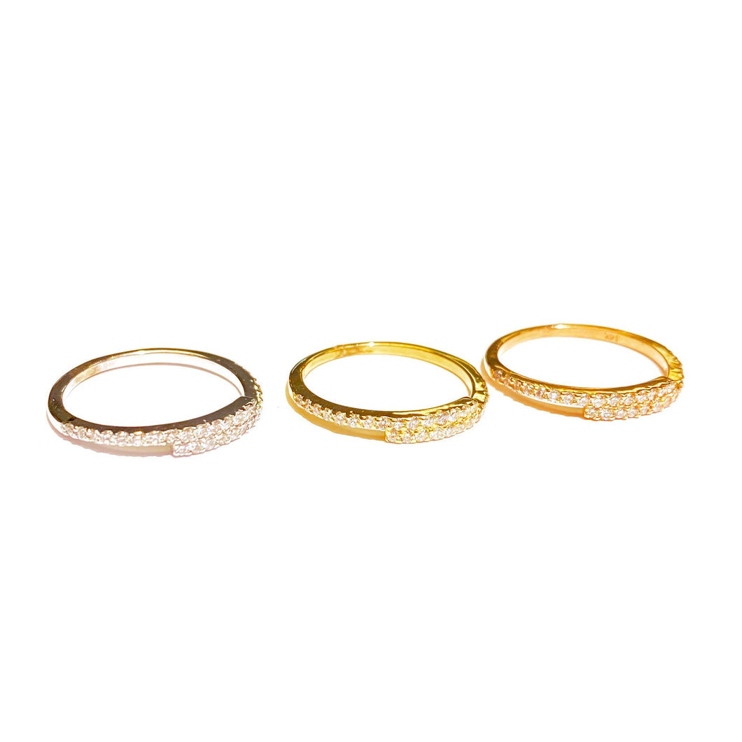 Three Diamond Offset Stackable Rings in 14k white, yellow, rose Gold laid flat on a white background.