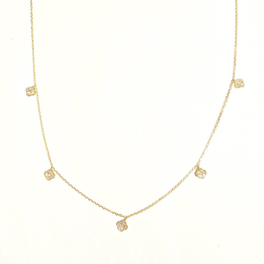 Karina Choker in 14k yellow gold with dangling mini diamond clovers laid flat on a white background.