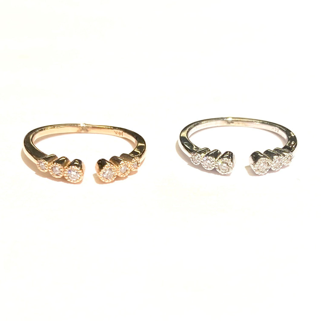 Two Open Graduated Diamond Ring in 14k yellow and white gold laid flat on a white background.