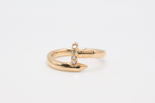Load image into Gallery viewer, Nail ring in 14k yellow gold with diamonds on a ring stand on a white background.
